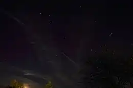 photograph of night sky above a dimly-lit horizon