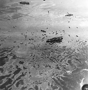 Three ships and smaller boats in an oil slick
