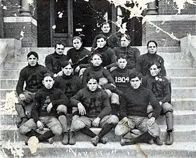 Black & white image illustrating 14 American football players in their uniforms with a single "A" visible on most jerseys and "1904" visible on one