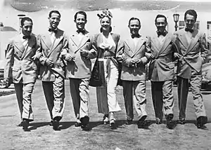 Carmen Miranda and the members of the musical group Bando da Lua (from left to right: Zé Carioca, Vadico, Nestor Amaral, Afonso, Stenio and Aloísio de Oliveira).