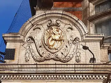 Terracotta corner decoration with golden griffin emblem