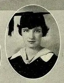 A young white woman wearing an academic cap and gown