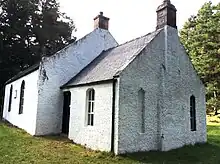 A white, single-storey building in a rural setting