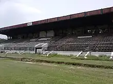 Large, disused grandstand with the letters RCTC on the roof