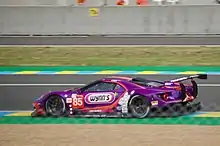 A purple Ford GT with the number 85 inside a purple square painted to the right of the front-left wheel as viewed from the side