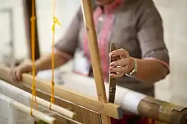 Pineapple-plant fiber and silk threads being woven in a traditional loom.
