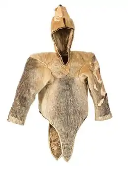 A fawn-brown and grey waist-length fur cape, with long sleeves and a hood. Sealskin woman's parka discovered at Qilakitsoq in 1972, dated to c. 1475.