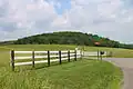 Fields, hills, woods, and a fence