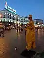 A Street artist at Puerta del Sol and the Tio Pepe Neon Advertisement photographed at Sunset.