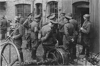 Stroop Report, showing Blösche at left. Original caption "Die Räumung eines Betriebes wird besprochen" {The clearance of a factory is being discussed-Herman Brauer helm repair shop at Nalewki 28–38. 24 April 1943}.