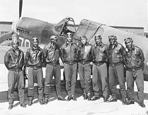 A group of Tuskegee Airmen posing with a P-40 during World War II