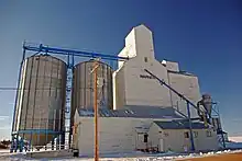 Grain elevator on snow, against a blue sky