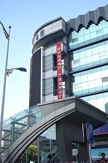 A vertical, red banner hanging high on a building with Chinese writing: "维护法律尊严,严惩犯罪分子"